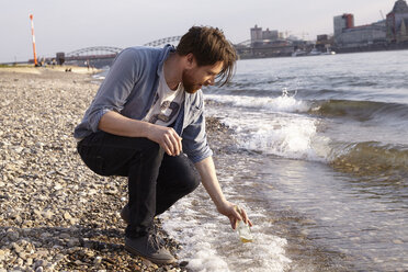 Mann mit Bierflasche am Fluss - FMKF001181