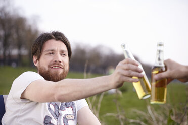 Two friends with beer bottles outdoors - FMKF001194