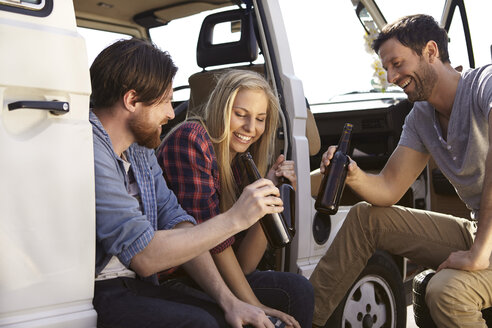 Fröhliche Freunde beim Feiern im Minivan - FMKF001239