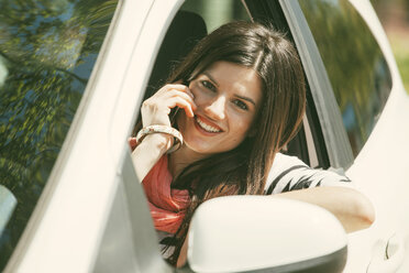 Spanien, Barcelona, Junge Frau im Auto beim Telefonieren - EBSF000225