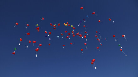 Deutschland, Bayern, Rote herzförmige Luftballons mit Botschaften am Himmel, Hochzeitstradition - RDF001286