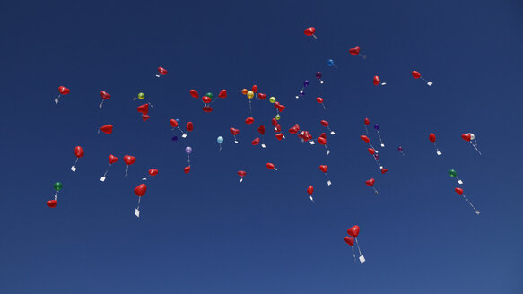 Deutschland, Bayern, Rote herzförmige Luftballons mit Botschaften am Himmel, Hochzeitstradition - RDF001286