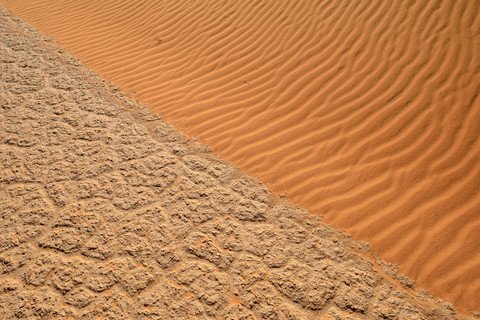 Algerien, Tassili n Ajjer, Sahara, Salz- und Lehmpfanne trifft auf Sanddüne, lizenzfreies Stockfoto