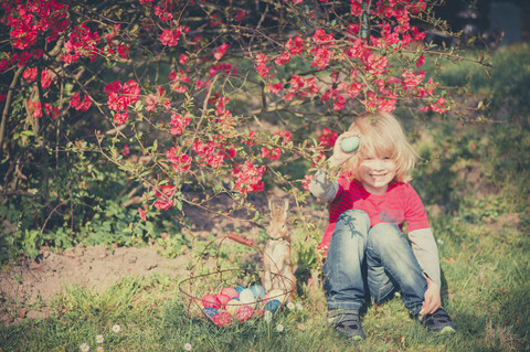 Junge im Garten mit Osterei, lizenzfreies Stockfoto