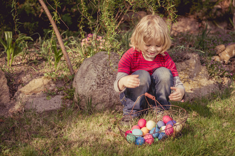 Junge mit Osterkorb im Garten, lizenzfreies Stockfoto