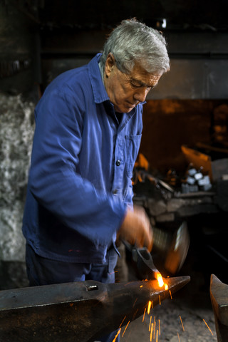 Germany, Bavaria, Josefsthal, blacksmith working on pickaroon at historic blacksmith's shop stock photo