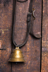 Germany, Bavaria, Josefsthal, little cow bell infront of wooden wall at historic blacksmith's shop - TCF003933