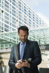 Businessman using digital tablet outdoors - UUF000356