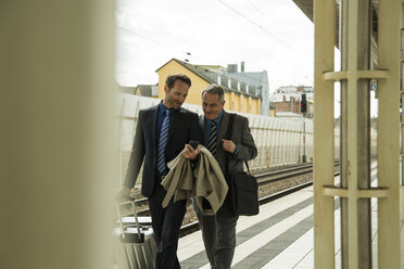 Zwei Geschäftsleute unterhalten sich am Bahnhof - UUF000455