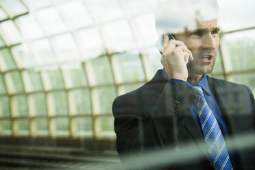 Businessman at train station on the phone - UUF000371