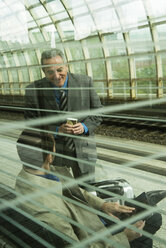 Two businessmen talking at train station - UUF000377