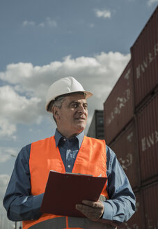 Mann mit Klemmbrett und Warnweste im Containerhafen - UUF000420