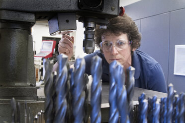 Germany, Freiburg, Female technician working in a metalworking workshop - SGF000596