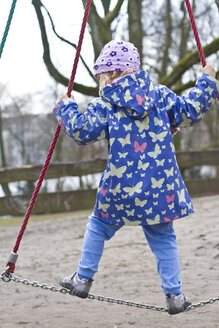 Kleines Mädchen balanciert auf Kette auf Spielplatz - JFEF000331