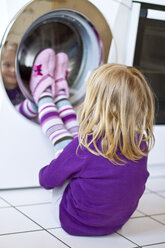 Kleines Mädchen beobachtet Waschmaschine - JFEF000408