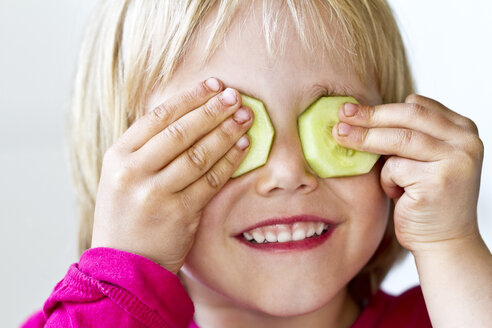 Porträt eines kleinen Mädchens mit zwei Gurkenscheiben auf den Augen - JFEF000354