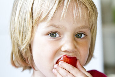 Porträt eines kleinen Mädchens, das eine Tomate isst - JFEF000409