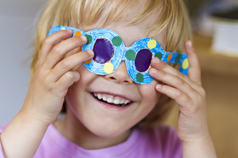 Little girl with her selfmade paper glasses stock photo