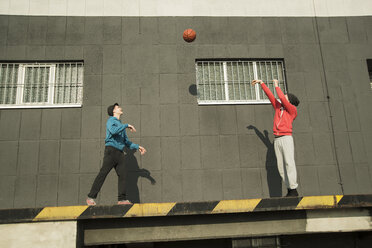 Young man and teenager playing basketball - UUF000433