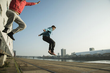Junger Mann und Teenager springen in der Luft - UUF000463