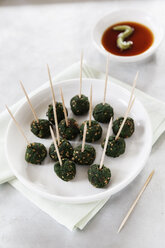 Plate of skewered spinach sesame balls and dipping bowl of sauce - EVGF000556