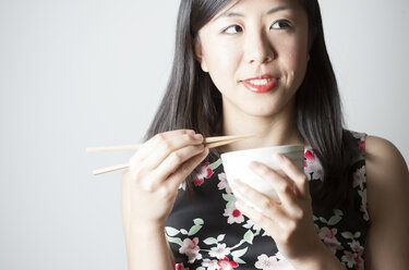 Portrait of Asian woman eating with chopsticks - FLF000510