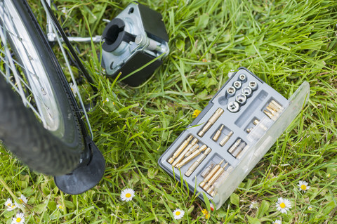 Werkzeugsatz für die Reparatur eines im Gras liegenden Fahrrads, lizenzfreies Stockfoto