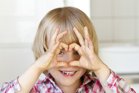 Porträt eines kleinen Mädchens, das mit den Fingern ein Herz formt, lizenzfreies Stockfoto