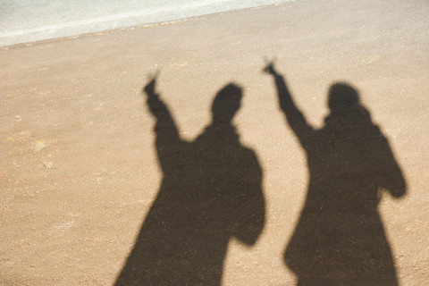 Portugal, Azoren, Sao Miguel, Schatten auf Mann und Frau im Sand, lizenzfreies Stockfoto