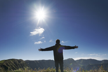 Portugal, Azores,Sao Miguel, Man standing with arms outstretched at Caldeira das Sete Cidades - ONF000445