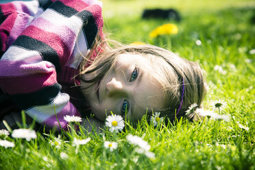 Porträt eines kleinen Mädchens auf einer Wiese liegend - SARF000556