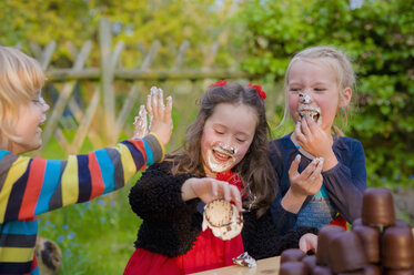 Drei Kinder machen einen Essenswettbewerb mit Schokoladen-Marshmallows - MJF001096