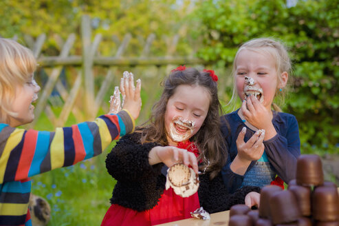 Drei Kinder machen einen Essenswettbewerb mit Schokoladen-Marshmallows - MJF001096