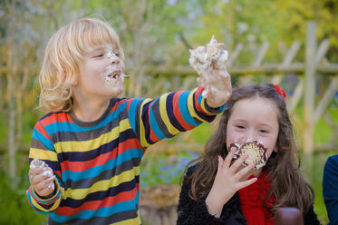 Drei Kinder machen einen Essenswettbewerb mit Schokoladen-Marshmallows - MJF001097