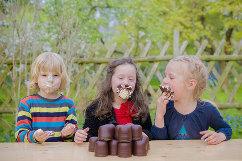 Drei Kinder machen einen Essenswettbewerb mit Schokoladen-Marshmallows - MJF001098
