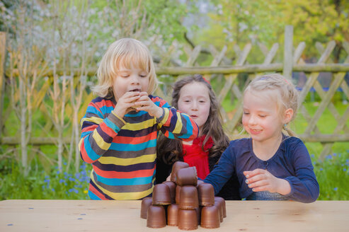 Drei Kinder machen einen Essenswettbewerb mit Schokoladen-Marshmallows - MJF001099