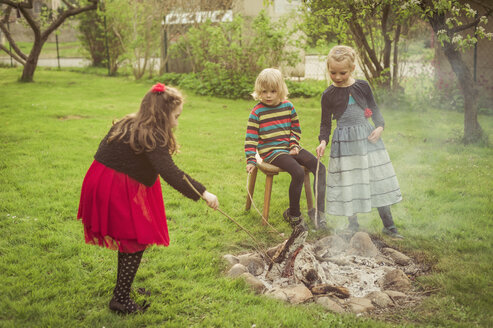 Drei Kinder mit Lagerfeuer im Garten - MJF001100