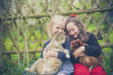 Porträt von zwei kleinen Mädchen mit Katze und Huhn, lizenzfreies Stockfoto