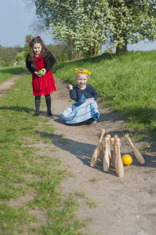 Two little girls bowling on the way stock photo