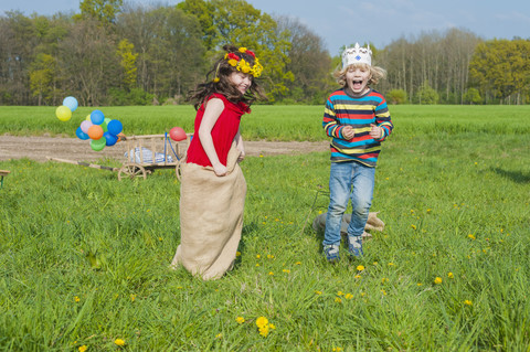 Zwei Kinder Sackhüpfen auf der Wiese, lizenzfreies Stockfoto