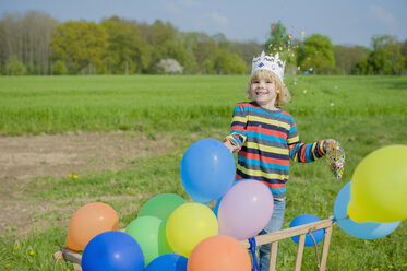Smiling little boy throwing confetti - MJF001134