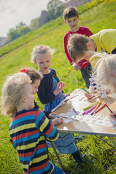 Children painting paper crowns for birthday party - MJF001147