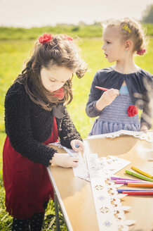 Zwei kleine Mädchen malen Papierkronen für eine Geburtstagsfeier - MJF001161