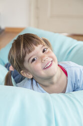 Portrait of smiling little girl lying on bean bag - LVF001166