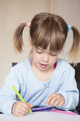 Portrait of little girl painting with wax crayons - LVF001164
