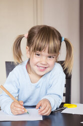 Porträt eines lächelnden kleinen Mädchens mit grünem Buntstift - LVF001173