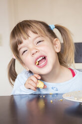 Porträt eines kleinen Mädchens, das mit offenem Mund Kuchen isst - LVF001169