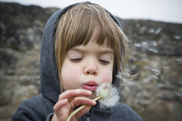 Porträt eines kleinen Mädchens, das eine Pusteblume bläst - LVF001147
