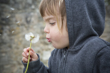 Porträt eines kleinen Mädchens, das eine Pusteblume bläst - LVF001149