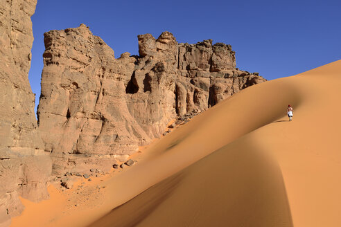 Algerien, Tassili n' Ajjer, Tadrart, Sahara, Tassili n' Ajjer National Park, Frau geht auf Sanddüne in Moul Nag - ES001028